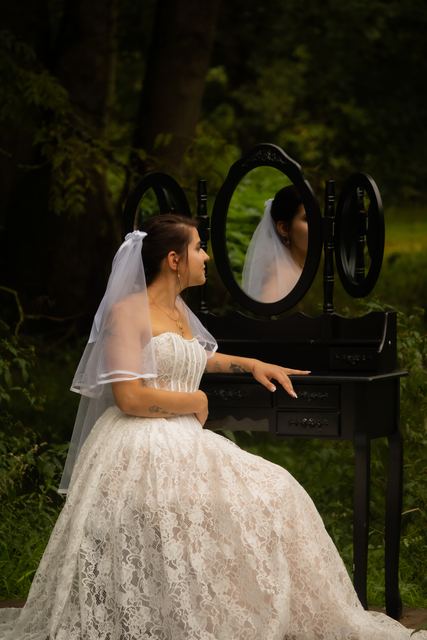 Mariée assise devant une coiffeuse noire en pleine nature